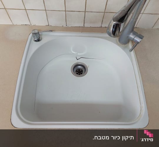 כיור עם סדק במשטח שיש בהיר